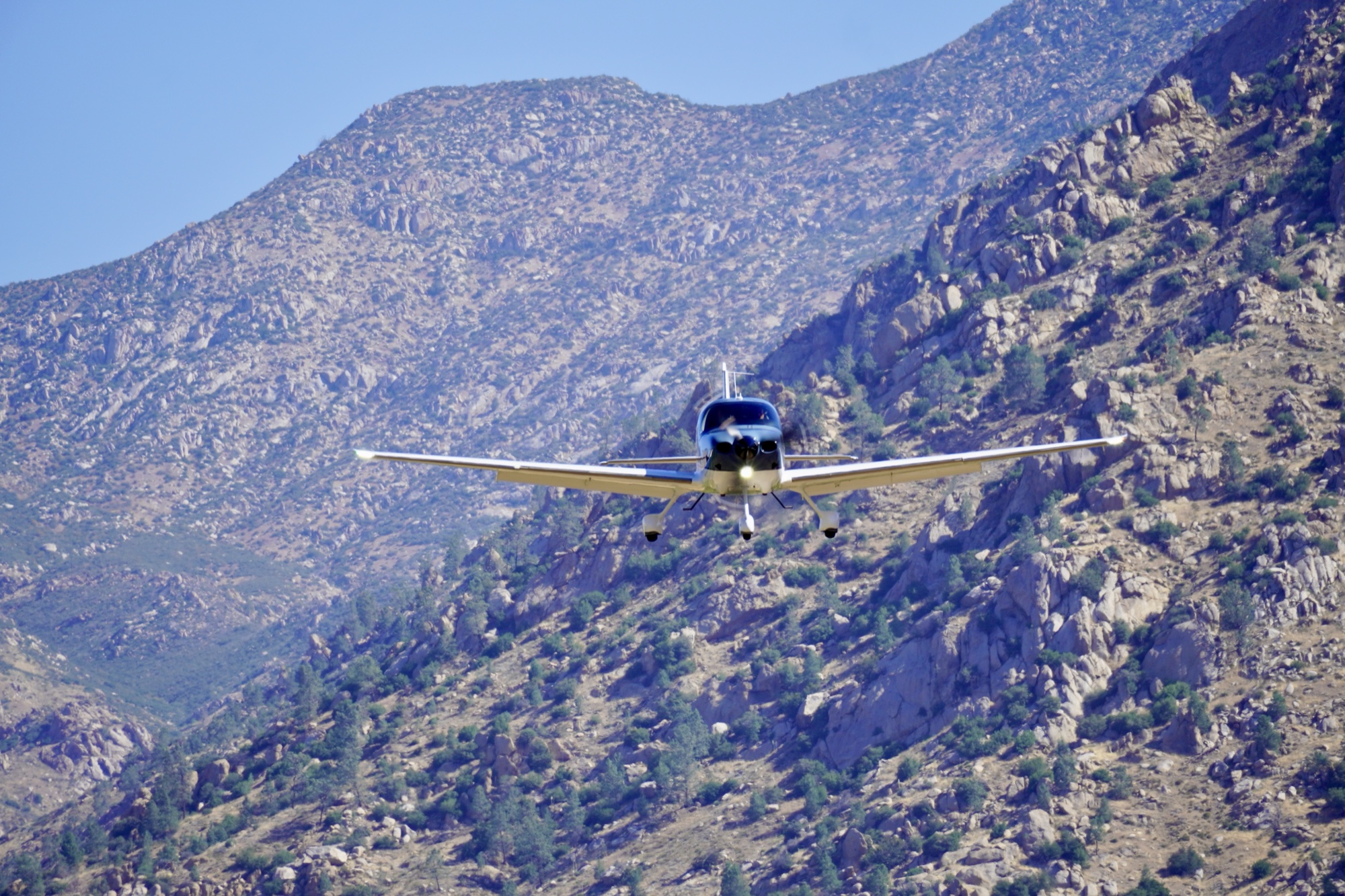 Kern Valley Flyout A low-wing aircraft on final into L05 against a steep rock face.